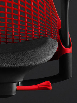 Close-up front view of a red and black Sayl gaming chair by Herman Miller, showing the contoured seat pad and red back.