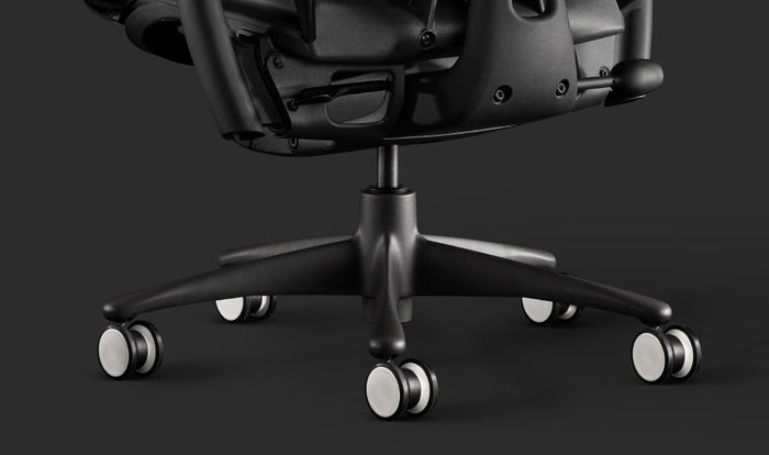 Close-up of a black Embody gaming chair by Herman Miller, showing the black and white castors.
