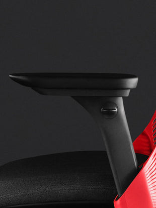 Close-up side view of a red and black Sayl gaming chair by Herman Miller, showing the adjustable arms.