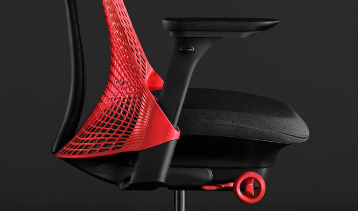 Close-up side view of a red and black Sayl gaming chair by Herman Miller, showing the contoured seat pad.