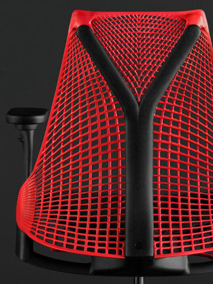 Rear view of a red and black Sayl gaming chair by Herman Miller, showing the Y-shaped back support.