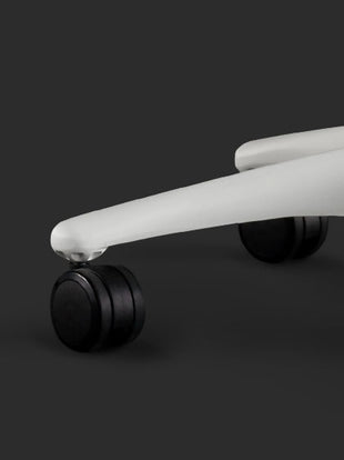 Close-up of a white Embody gaming chair by Herman Miller, showing the black castors.