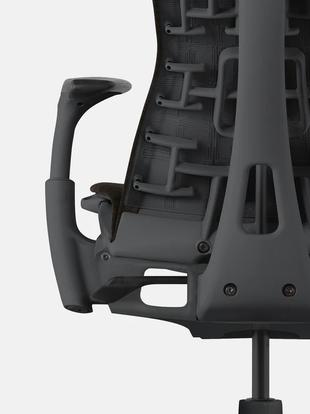Close-up of a black and grey Embody office chair by Herman Miller, showing the recline adjustment lever.