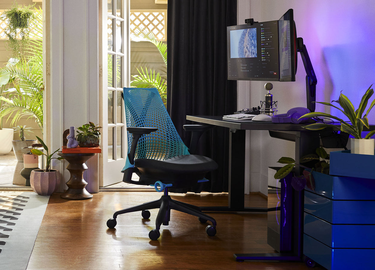 Photo of Friskk's gaming set up at home comprising of Sayl gaming chair in black and ocean blue with Nevi gaming desk in black