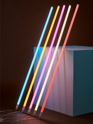 Five HAY neon LED tubes in an array of colours, leaned against a white cube.
