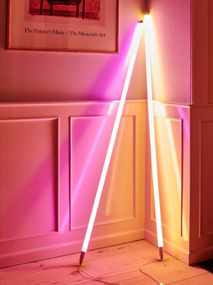 Two HAY neon LED tubes in pink and orange, leaned against a white wall.