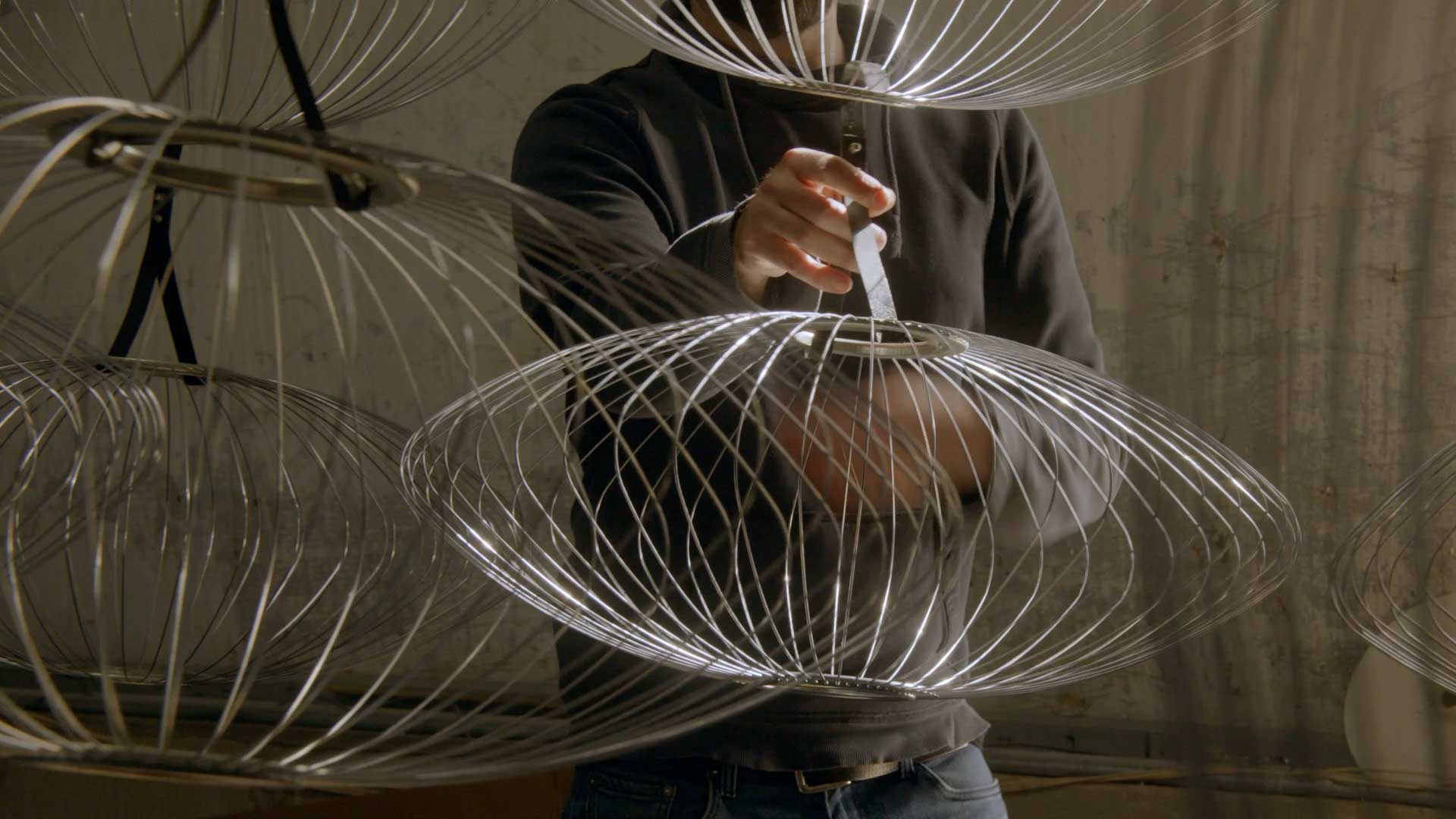 A skilled worker crafting the wire frames of a selection of Nelson Bubble light shades.