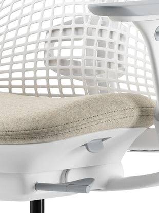 Close-up of a beige and white Sayl office chair by Herman Miller, showing the contoured seat.