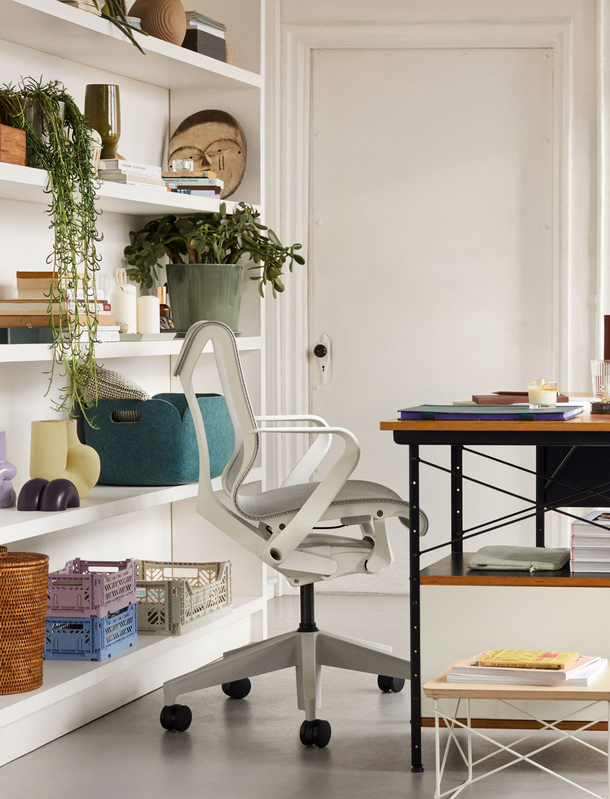 Home office featuring Cosm low back in mineral white in front some vertical shelves with Hay Storage crates and various ornaments