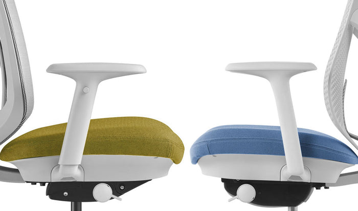 Side view of two Herman Miller Verus office chairs facing each other. The left chair shows the fully adjustable armrest and the right chair shows the fixed armrest.