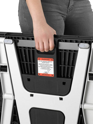 A person holding a folded Monto sit stand by Herman Miller.
