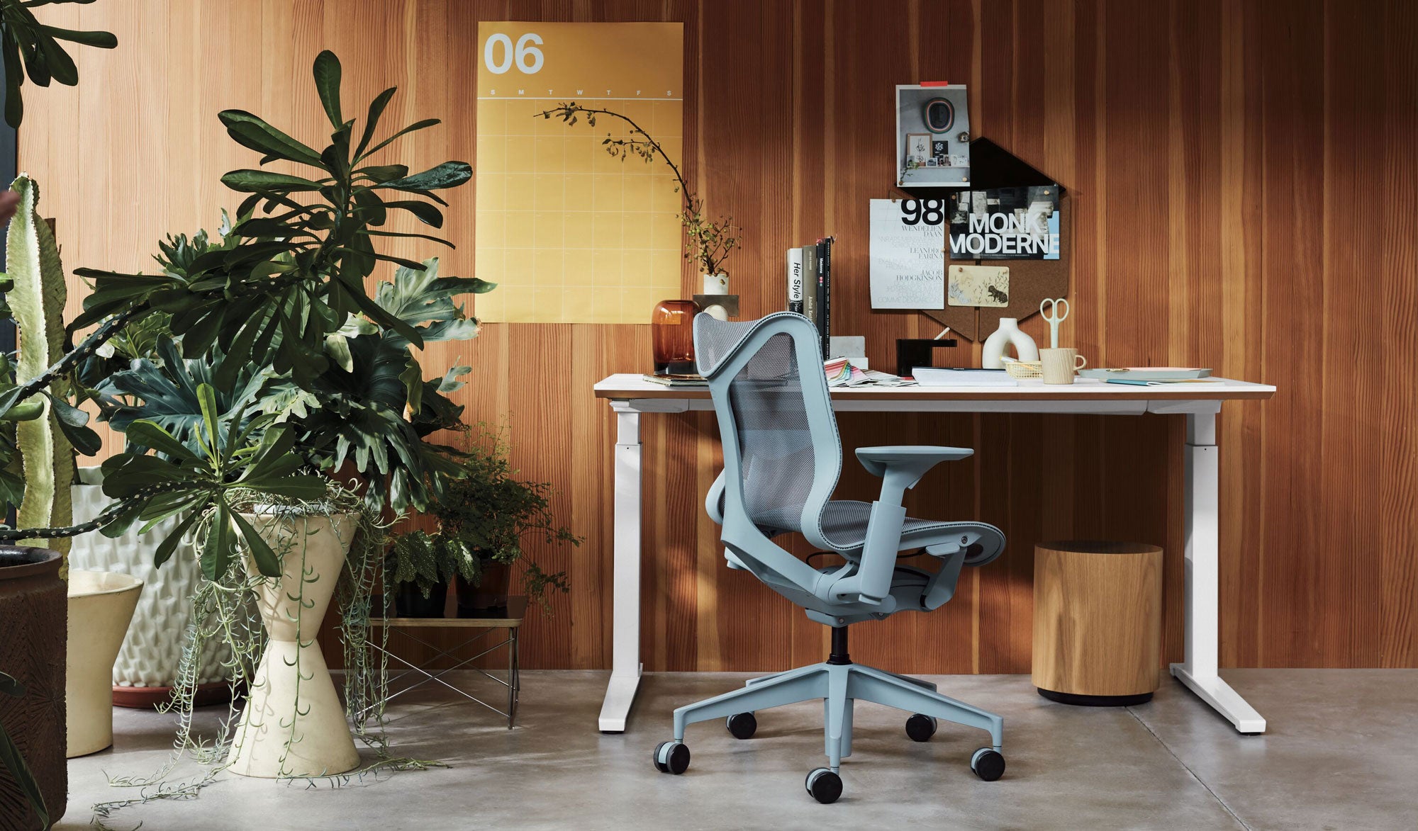 Home office setting featuring low back Cosm office chair in glacier grey in front of Nevi sit-stand desk with white legs and top