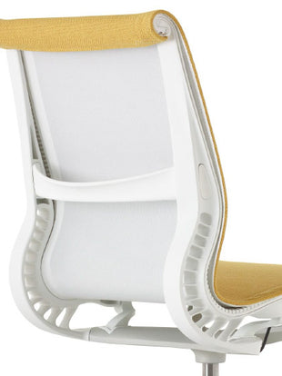 Rear view of a white and yellow Setu office chair by Herman Miller, showing the curved back support.
