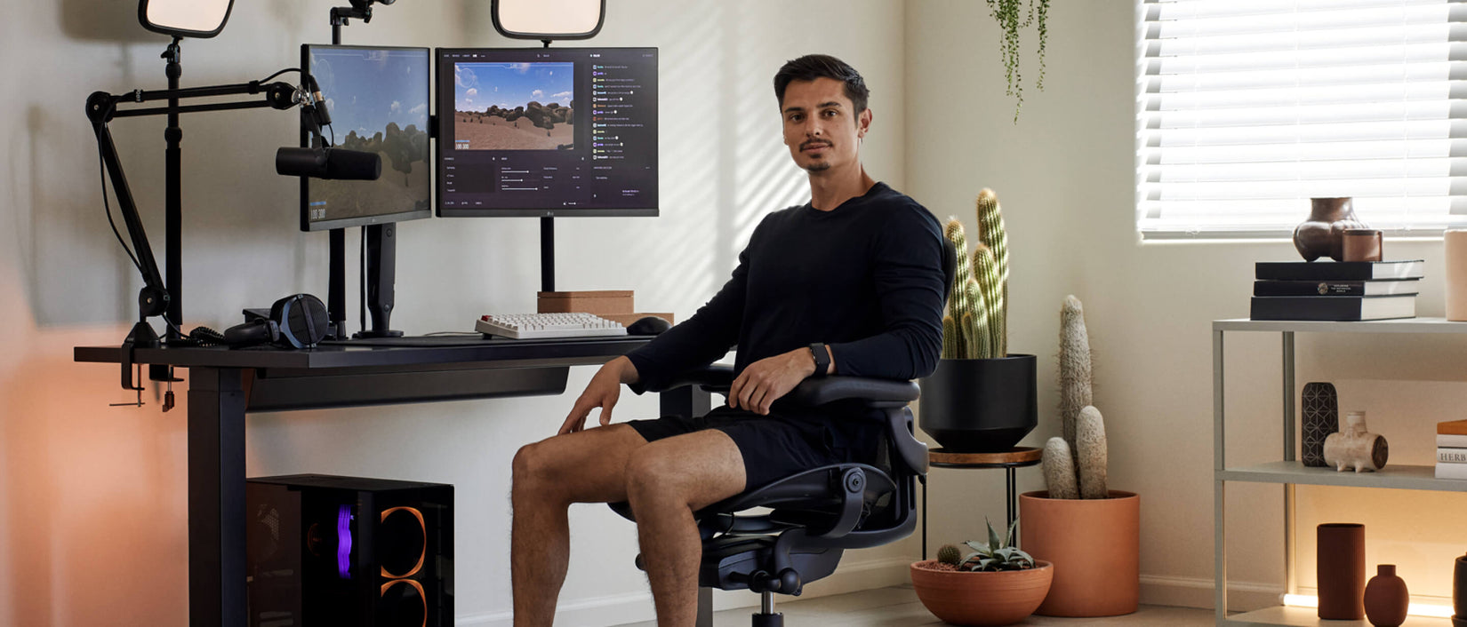 Picture of gamer Xaryu sat facing camera in Aeron gaming chair in graphite with gaming set up behind him with Nevi gaming desk and Ollin dual monitor arms
