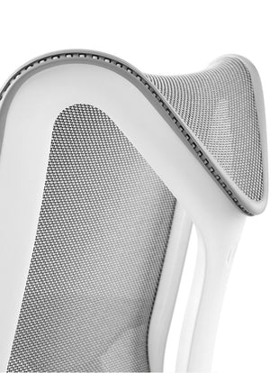 Close-up of a white and grey Cosm office chair by Herman Miller, showing the flexible frame.