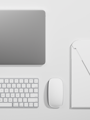 Top view of a white Oripura laptop stand by Herman Miller, laid out on a white table alongside a laptop, keyboard and mouse.