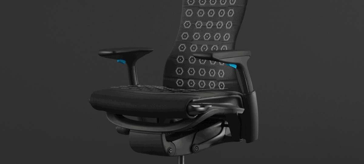 Font view of a black and blue Embody gaming chair by Herman Miller, overlaid with white graphics highlighting the seat and back.