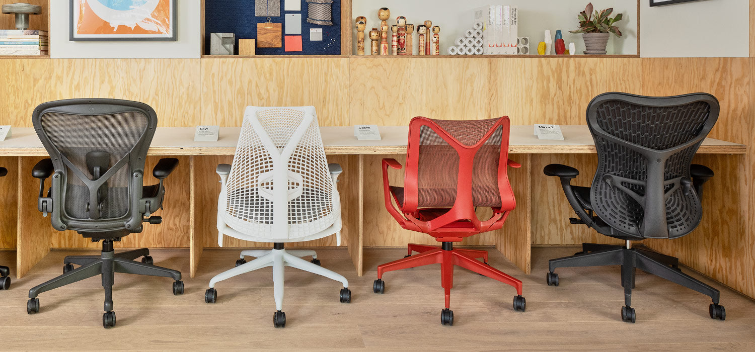 Rear view of Home office chairs including Aeron in graphite, Sayl in white, Cosm low back in canyon red and Mirra 2 in graphite