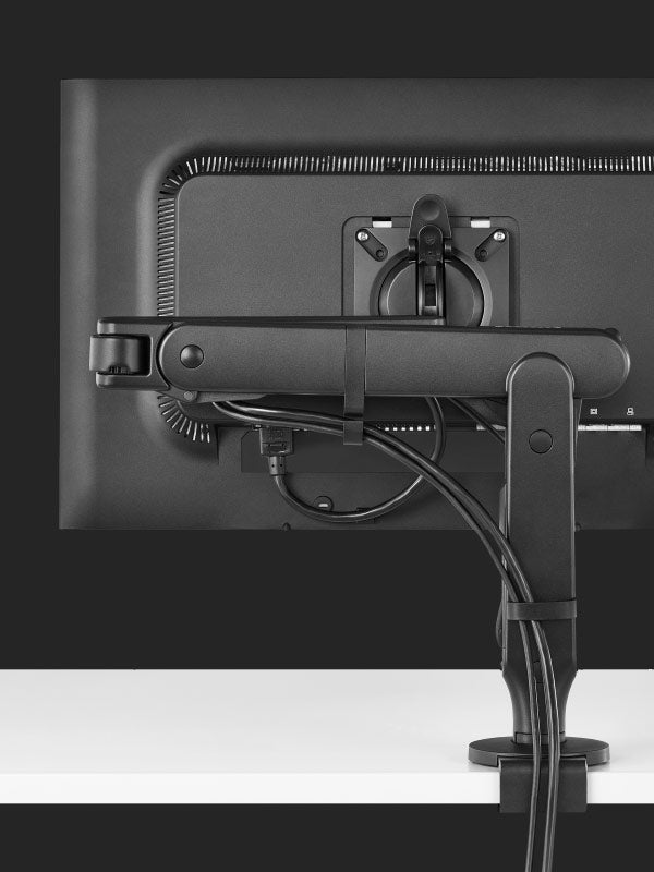 Rear view of a black Ollin gaming monitor arm by Herman Miller, showing the cable management feature.