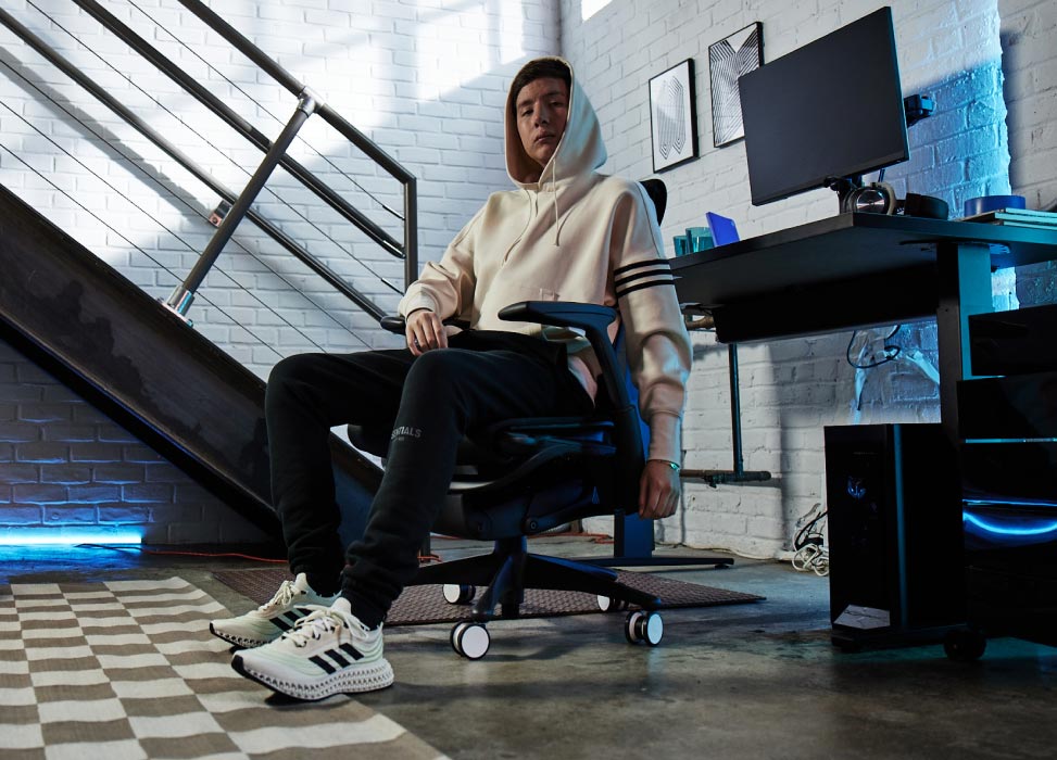 Picture of Jelty from G2 Esports team sat in G2 Embody chair with back to gaming set up including Nevi gaming desk in black with Ollin monitors