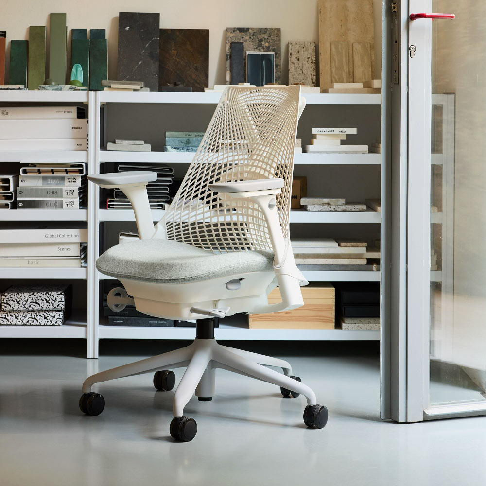 A white Herman Miller Sayl office chair with grey felted seat upholstery in a home studio.