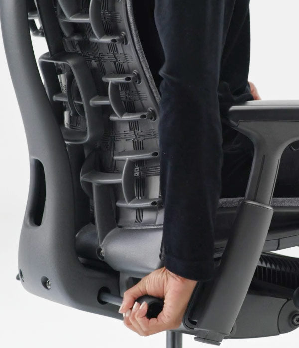 Close rear view of lumber support adjustment being used on Embody in black