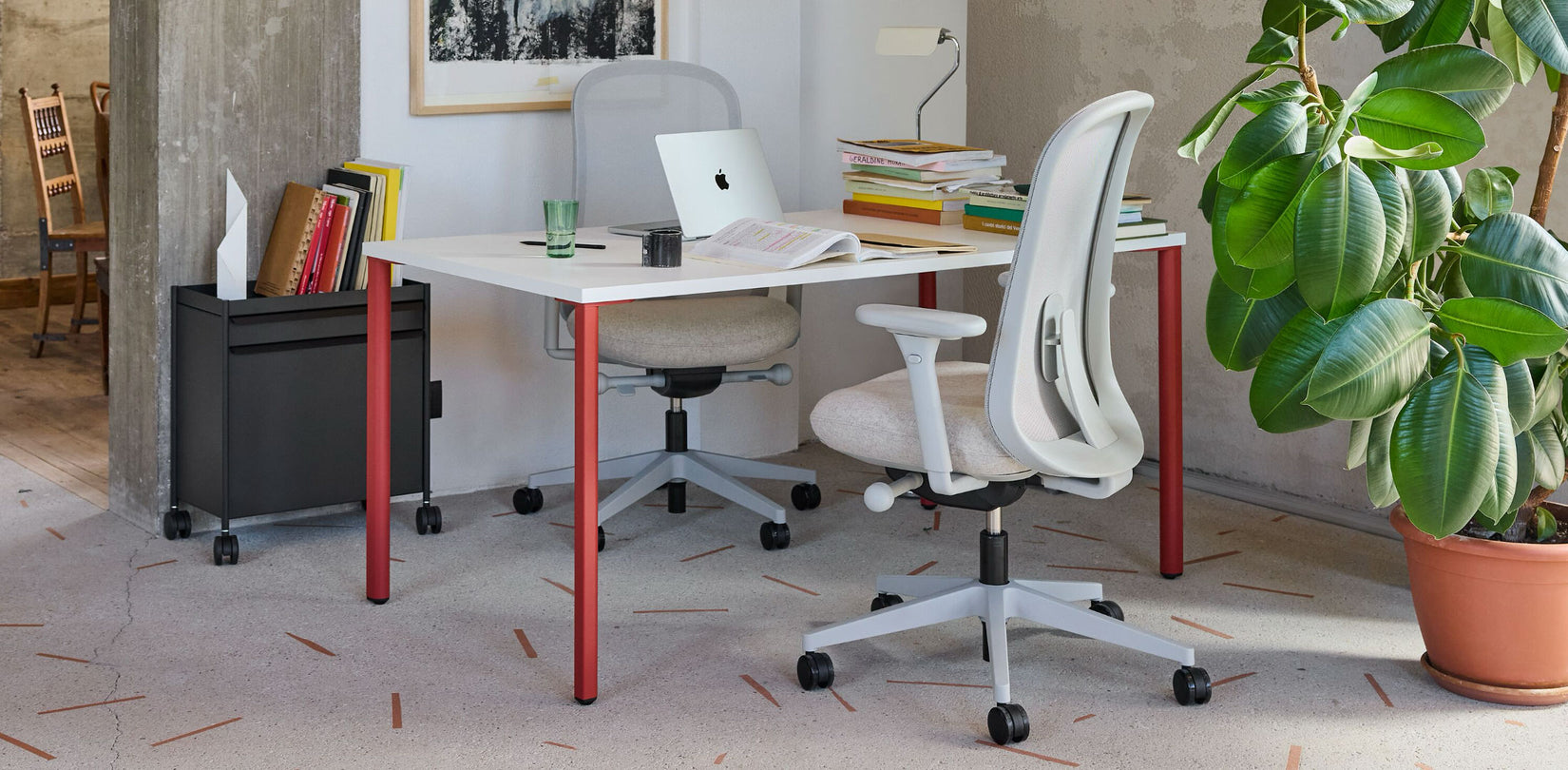 A collaborative home-office setup featuring two Herman Miller Lino chairs and a white OE1 desk with canyon red legs.