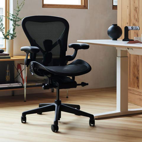 Aeron office chair in graphite in home office setting with Nevi sit stand desk with white legs and top