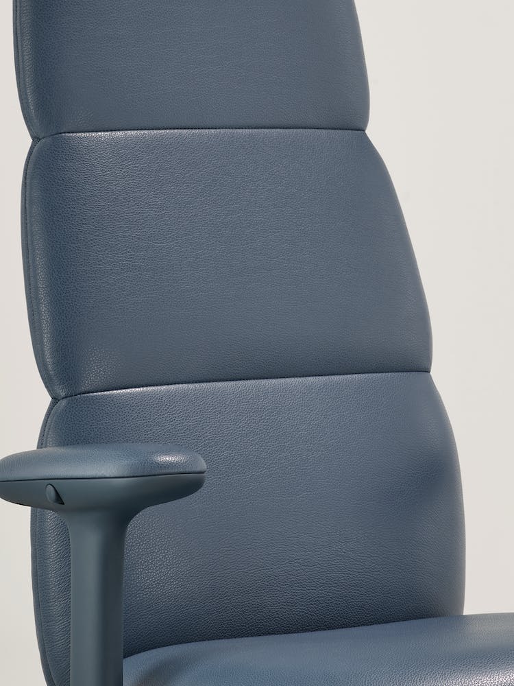 Close-up of a blue leather Asari office chair by Herman Miller, showing the integrated, internal Posturefit technology.