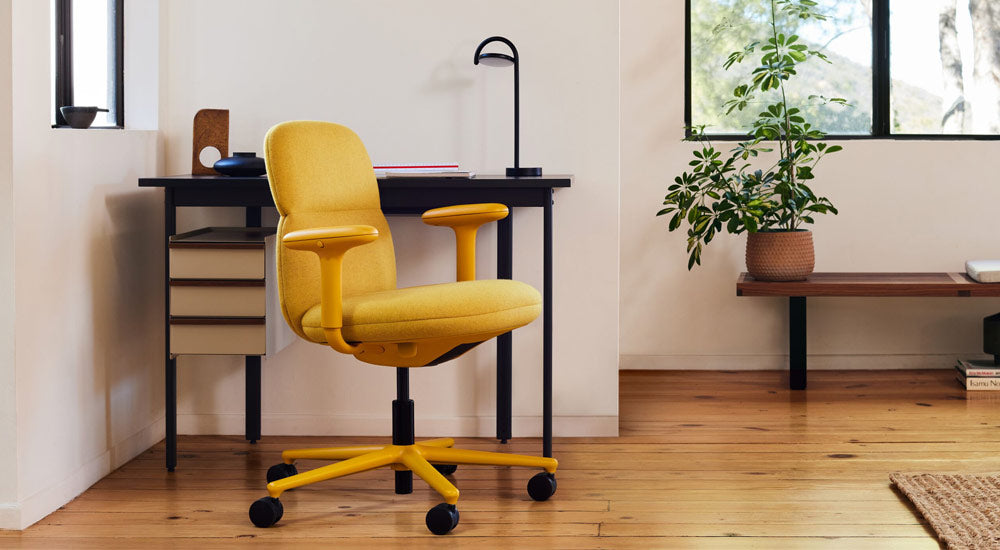 A yellow Asari office chair by Herman Miller, upholstered in Clarion Luce fabric by Maharam - with a Mode desk and Marselis lamp.