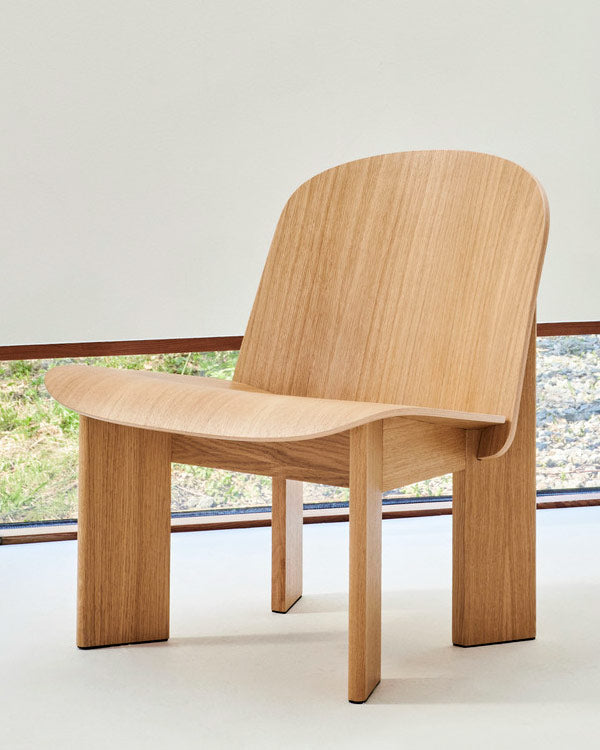 Front view of an oak Chisel lounge chair by HAY, set in an indoor home space with a minimalist style.