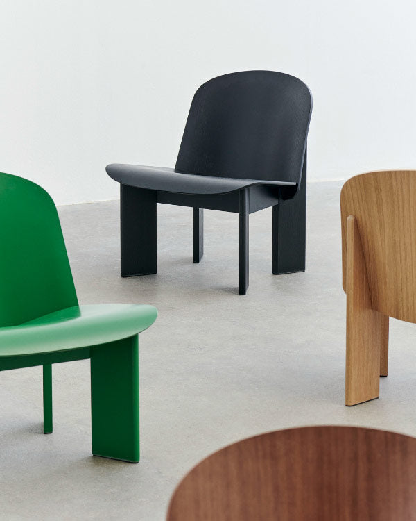 Group shot of four Chisel lounge chairs by HAY, showing the different colour options. Set in an indoor environment with concrete floors and white walls.
