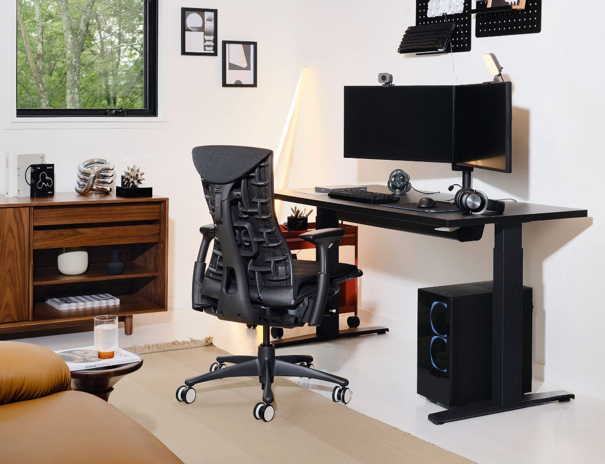 Herman Miller black Embody gaming chair with black Nevi sit-stand gaming desk with gaming set up inlcuding dual monitors