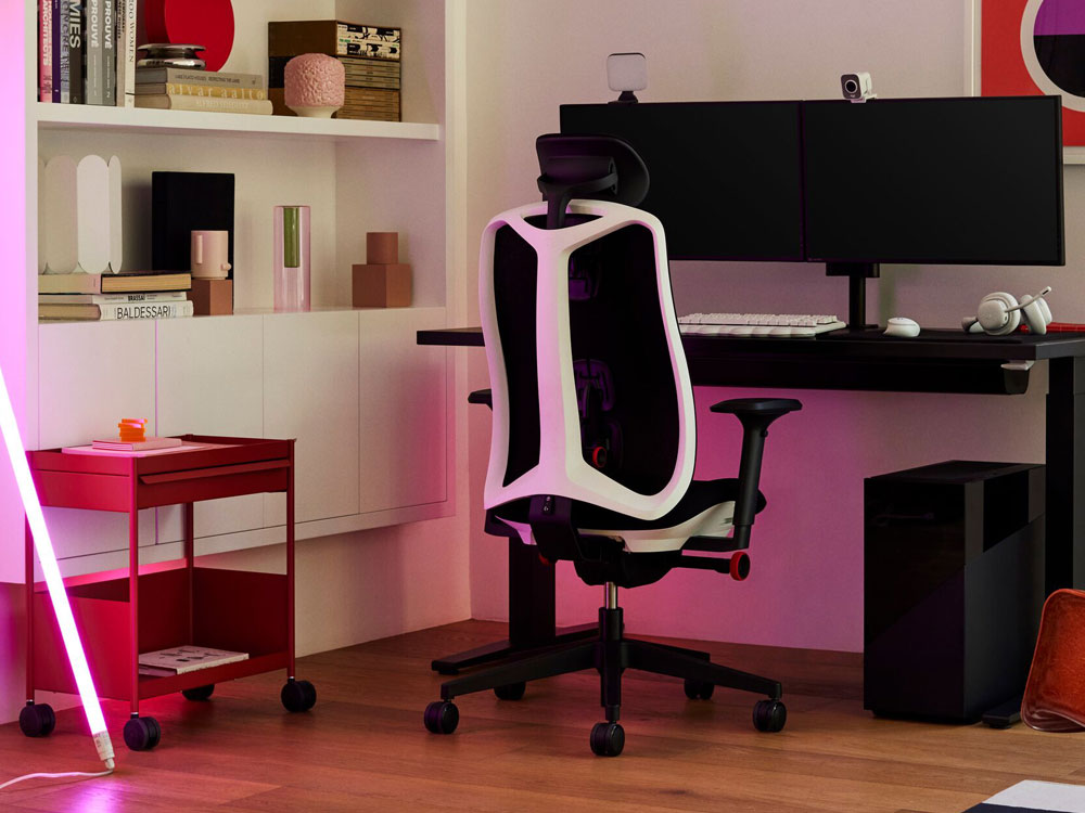A Logitech x Herman Miller Vantum gaming chair in white as part of a gaming setup. Features Nevi desk, Ollin monitor arm, OE1 trolley and a HAY neon LED tube.