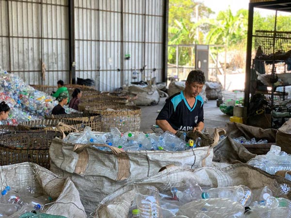 Photo of man sorting through the plastic recovered from oceans which are then cleaned and turned into pellets.