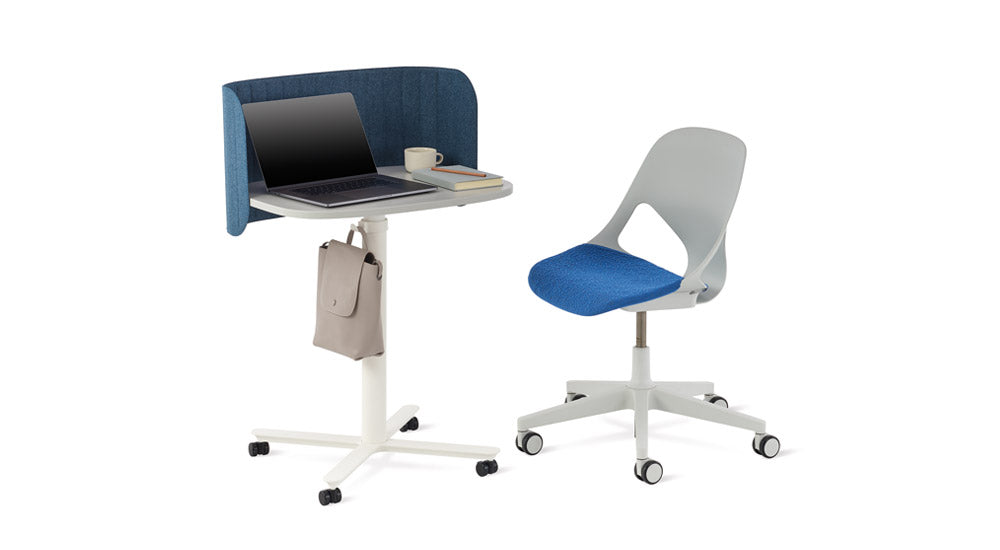 A white Passport work table by Herman Miller with a blue Passport desk screen. Positioned alongside a grey and blue Zeph office chair.