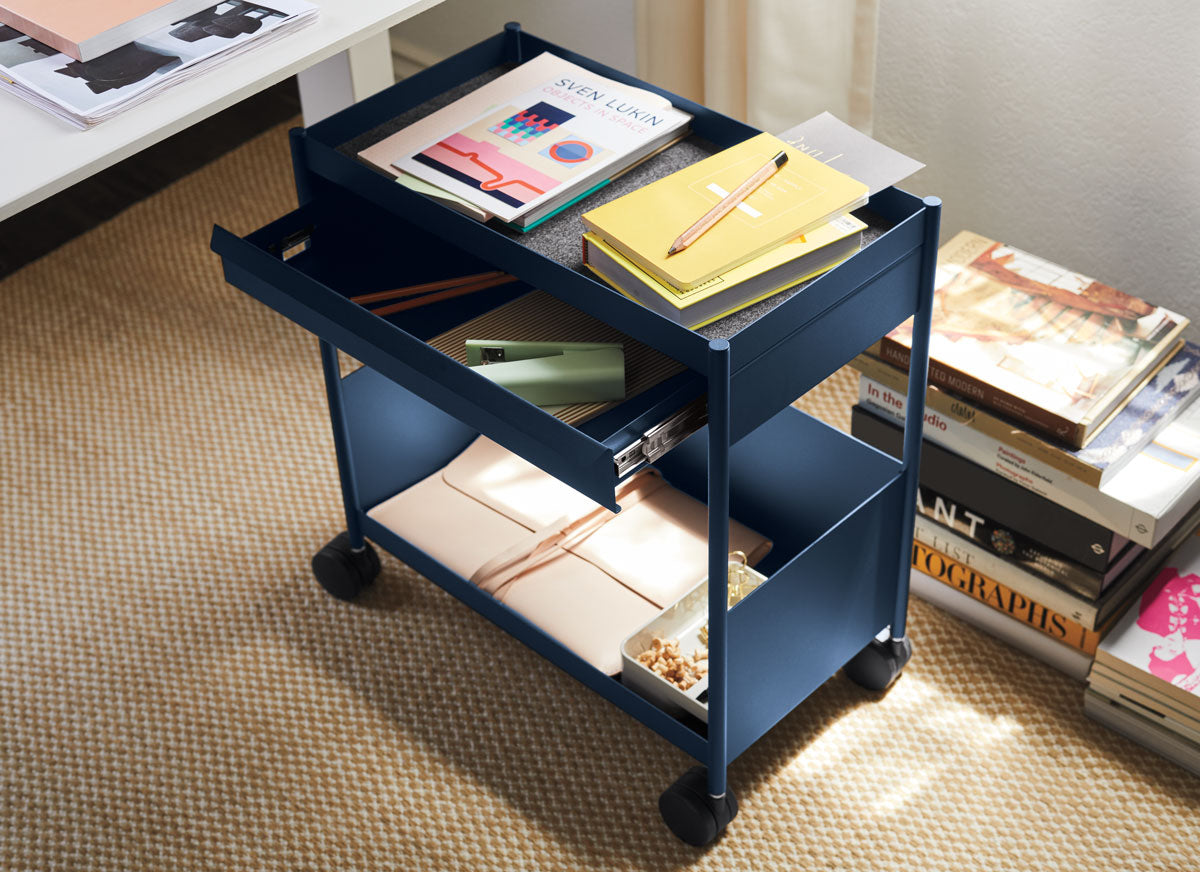 A navy blue Herman Miller OE1 office trolley with a stationary drawer and wheels.