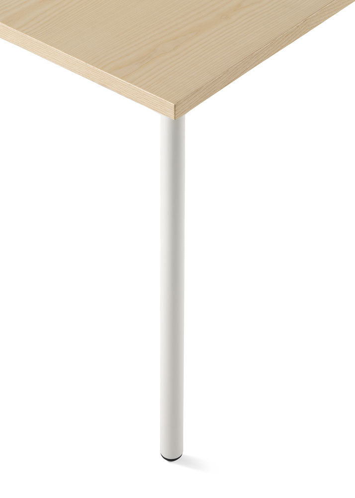 Close view of the white leg of a light oak Herman Miller OE1 desk.