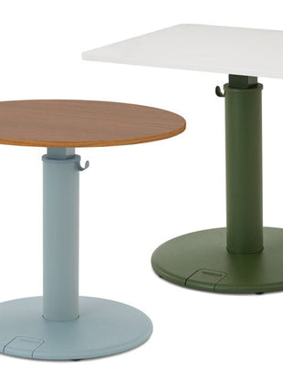 Two OE1 standing desks by Herman Miller, one with a round walnut tabletop and blue base, and one with a rectangular white tabletop and green base.