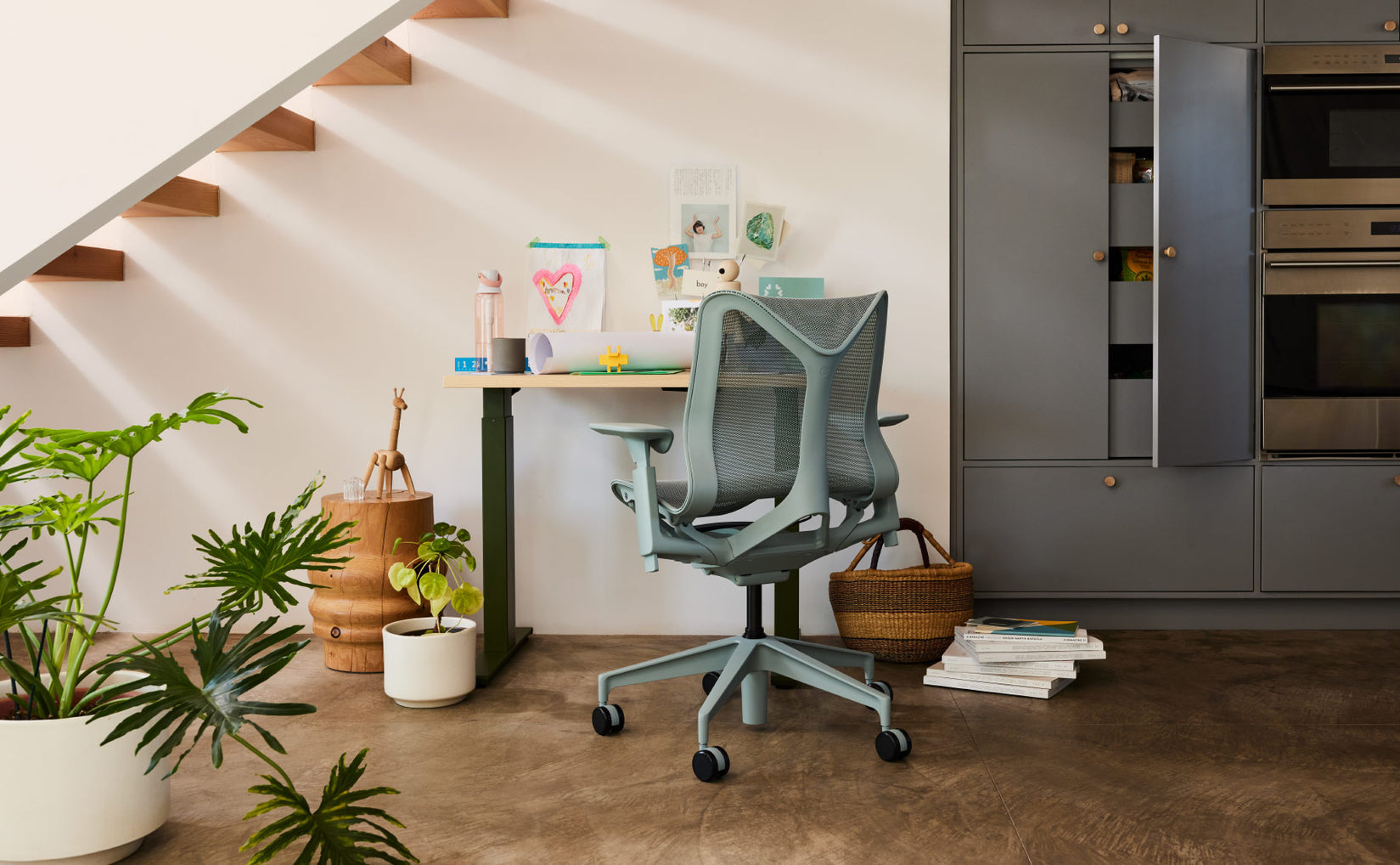 Home office space under staircase featuring Cosm low back in glacier grey in front of compact sit stand desk