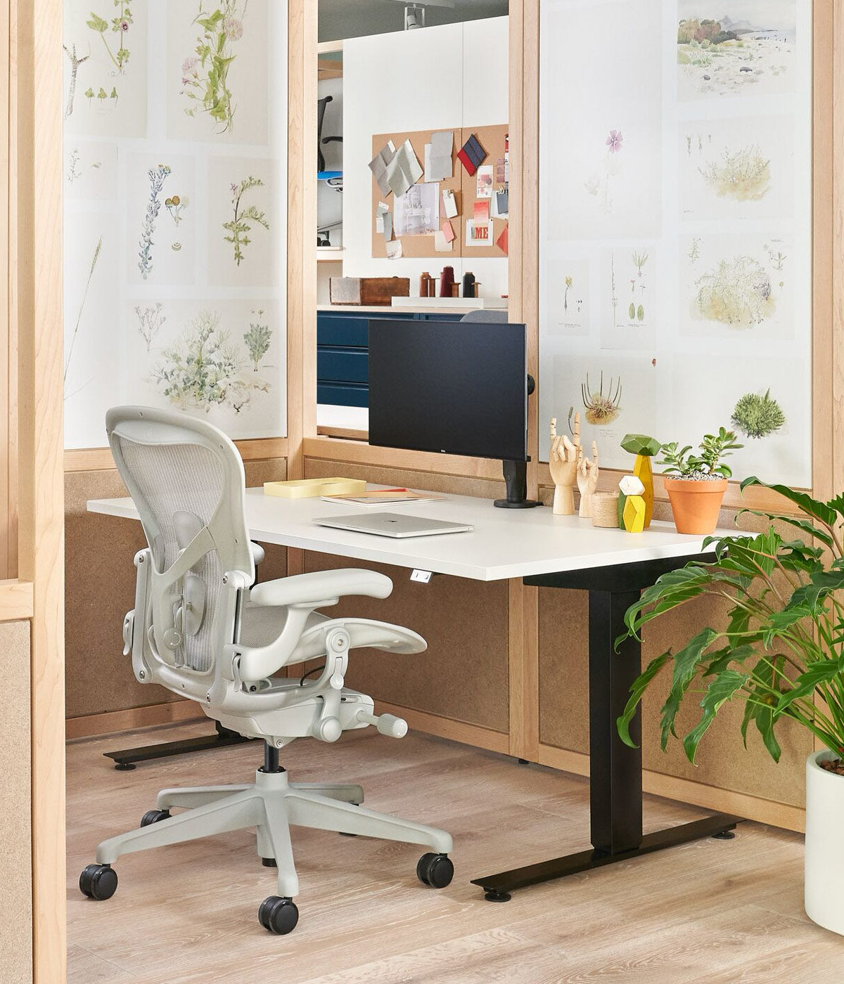 Home office containing Aeron office chair in mineral white wit sit-stand Nevi desk with black legs and white top