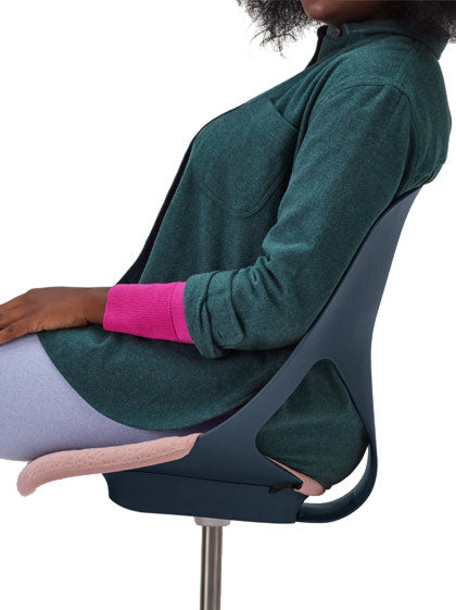 Side view of a person sitting in a blue Zeph office chair by Herman Miller with a pink seat pad.