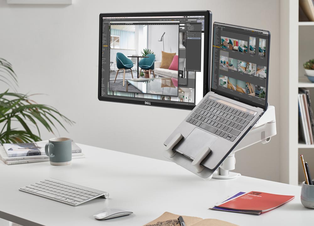 A white Lima dual monitor arm by CBS featuring a white laptop mount, showing the computer screen and laptop mount.