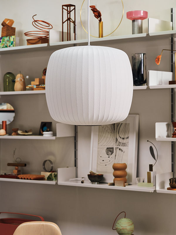 Close up of Roll Nelson Bubble ceiling pendant in hanging in front of shelves filled with iconic ornaments