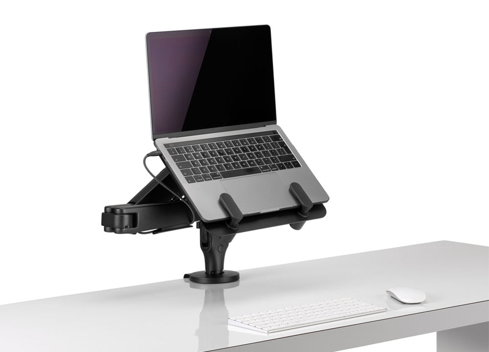 A black Ollin monitor arm and laptop mount by CBS, holding a laptop.
