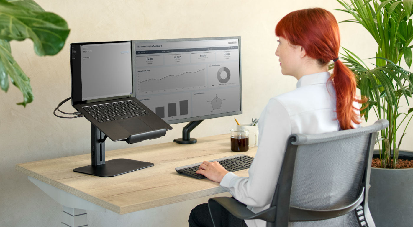 A lady using a home office setup with a Nevi desk, Setu chair and Lana laptop stand.